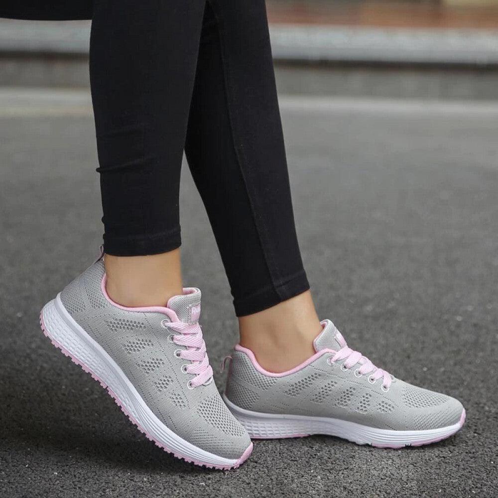 Graue Damen-Sneaker mit rosa Akzenten, atmungsaktiv, ideal für Laufen und Freizeit.