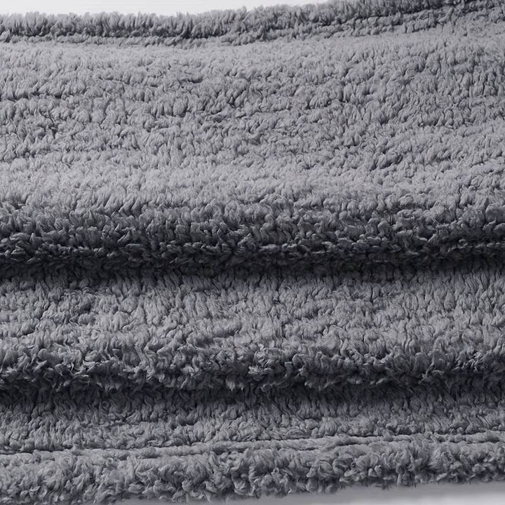Graue, flauschige Decke aus Fleece, ideal für gemütliche Abende, weiche Textur, warm.