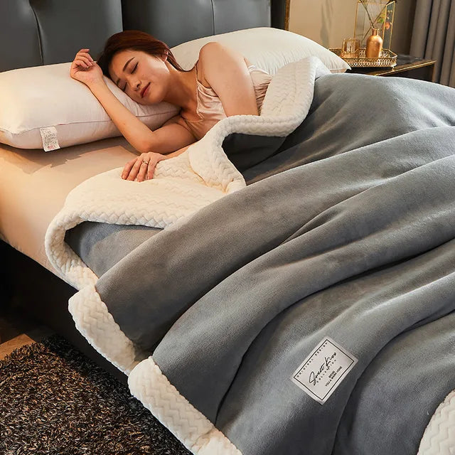Frau schläft unter grauer, weicher Decke mit weißem Rand auf einem Bett, gemütliches Schlafzimmer.