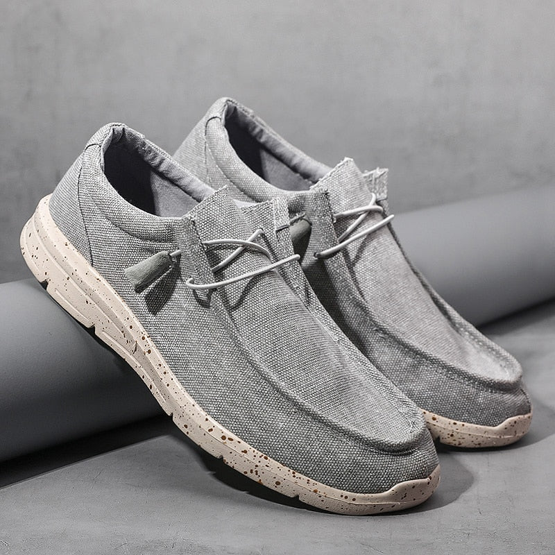 Graue Herren-Sneaker aus Leinen, lässig, mit weißer Sohle, ideal für Freizeitkleidung.