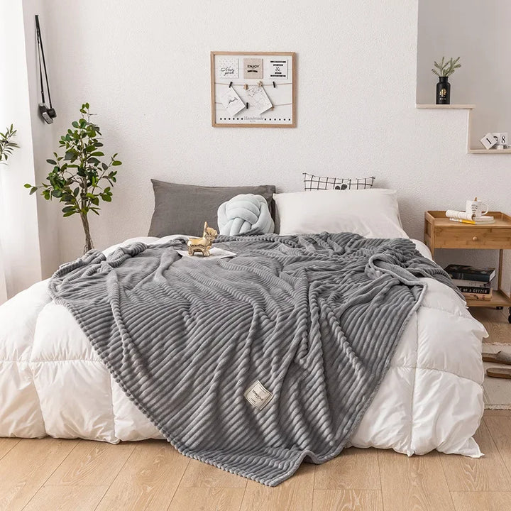 Graue, gerippte Kuscheldecke auf Bett, Schlafzimmerdekor, gemütlich, modern, stilvoll.