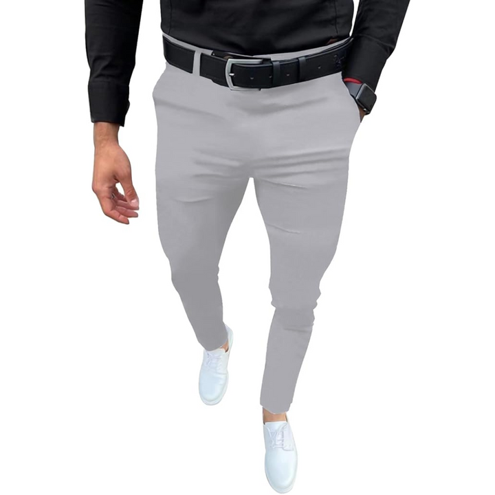 Mann in grauer Hose und schwarzem Hemd, weiße Sneaker, schwarzer Gürtel, modisch, elegant.