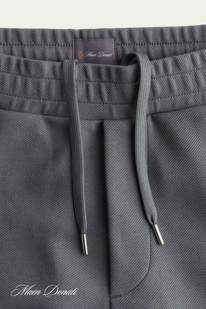 Graue Jogginghose mit Kordelzug, elastischer Bund, Mikrofaserstoff, sportlich, bequem.