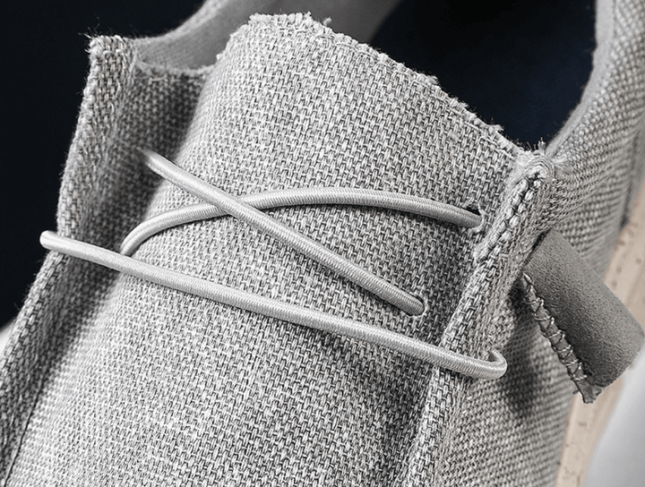 Graue Leinen-Loafer mit Schnürsenkeln, Nahaufnahme, modische Herrenschuhe, Textilmaterial.