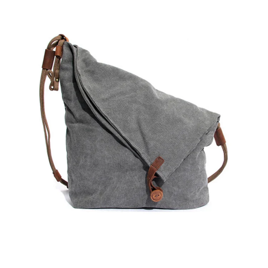 Graue Canvas-Umhängetasche mit braunen Lederriemen, lässiges Design, ideal für den Alltag.