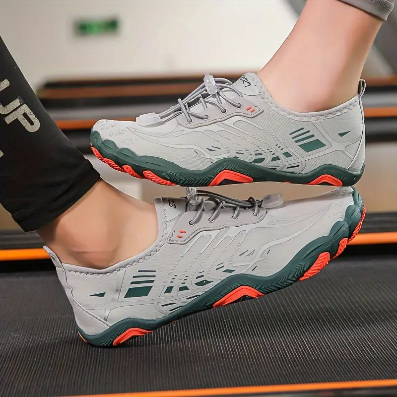 Graue Sportschuhe mit roter Sohle, atmungsaktiv, ideal für Outdoor-Aktivitäten, Unisex-Design.
