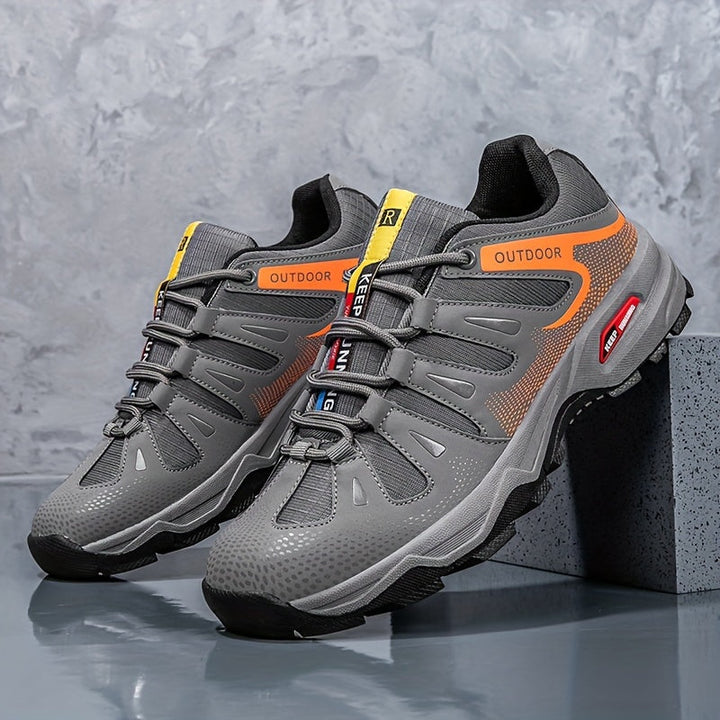 Graue Outdoor-Sneaker mit orangefarbenen Akzenten, atmungsaktiv, rutschfeste Sohle.
