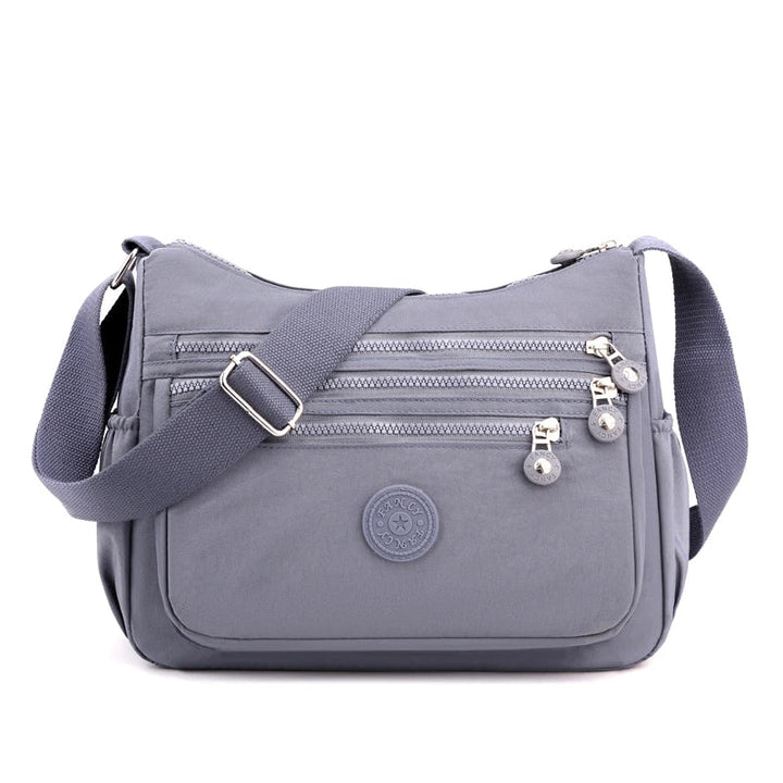 Graue Umhängetasche aus Nylon mit Reißverschlüssen, verstellbarem Gurt, Damenmode Accessoire.