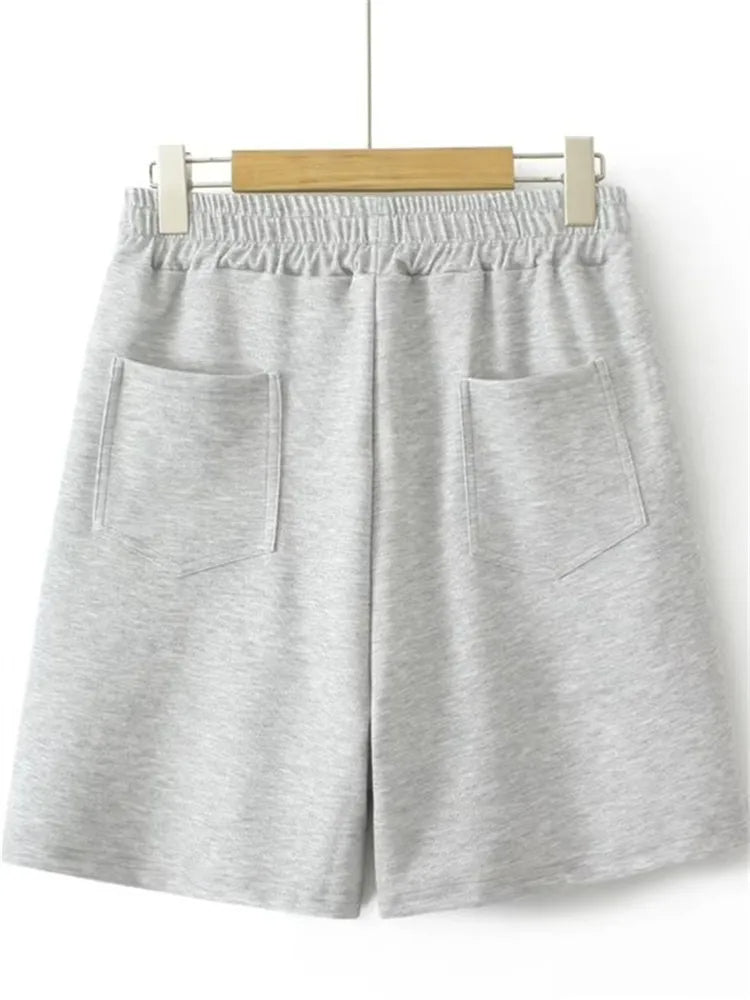 Graue Baumwollshorts mit elastischem Bund und Taschen, bequem für Freizeit und Sport.
