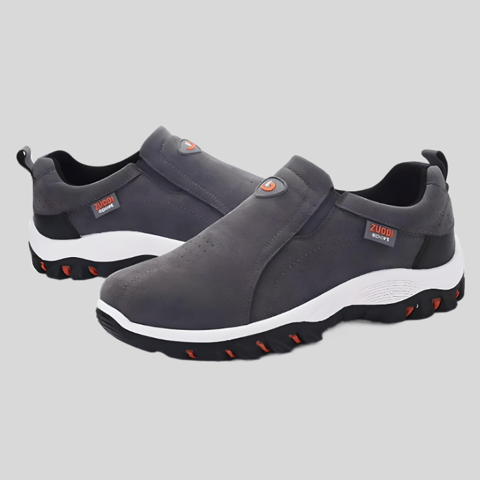Graue Herren-Sneaker, rutschfest, atmungsaktiv, sportlich, mit weißer Sohle und rotem Akzent.