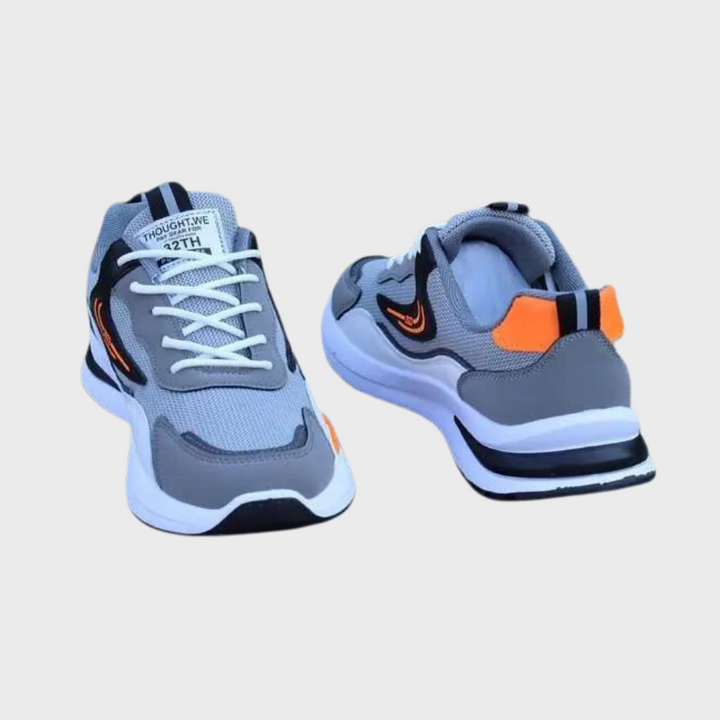 Graue Sportschuhe mit orangefarbenen Akzenten, atmungsaktives Mesh, rutschfeste Sohle.