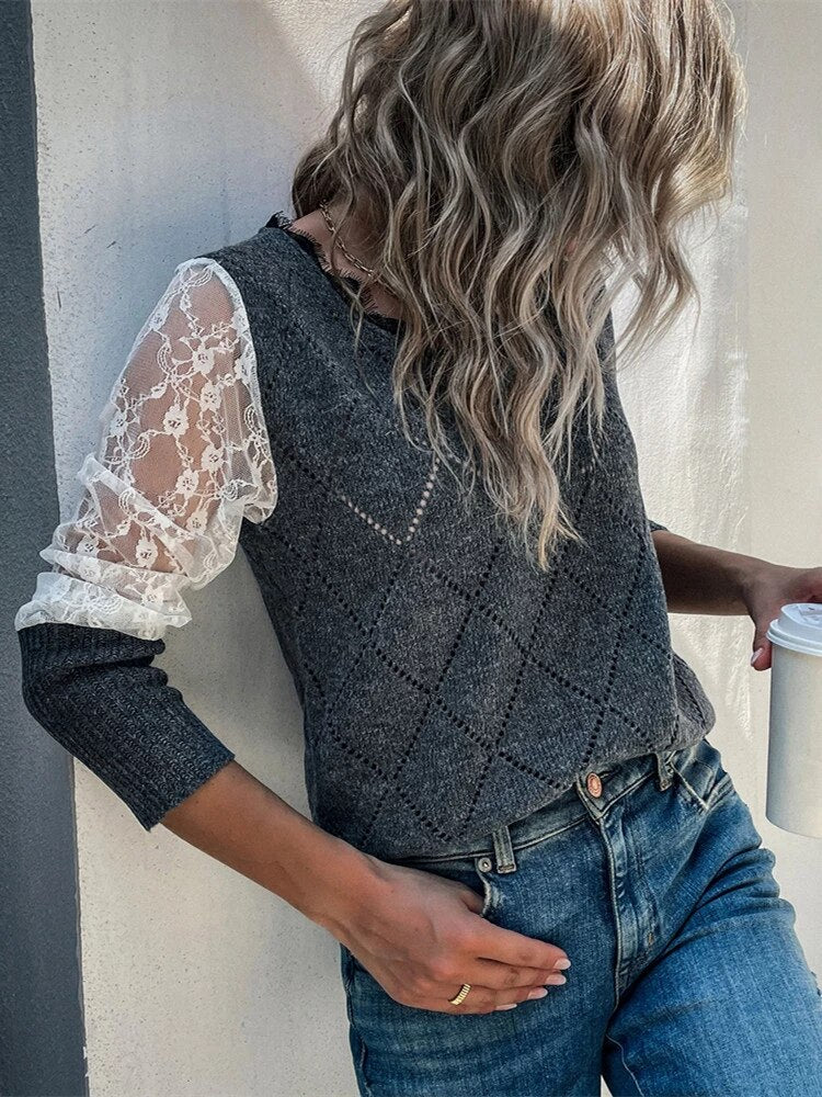 Frau in grauem V-Ausschnitt-Pullover mit Spitzenärmeln, hält Kaffeebecher, modische Damenbekleidung.
