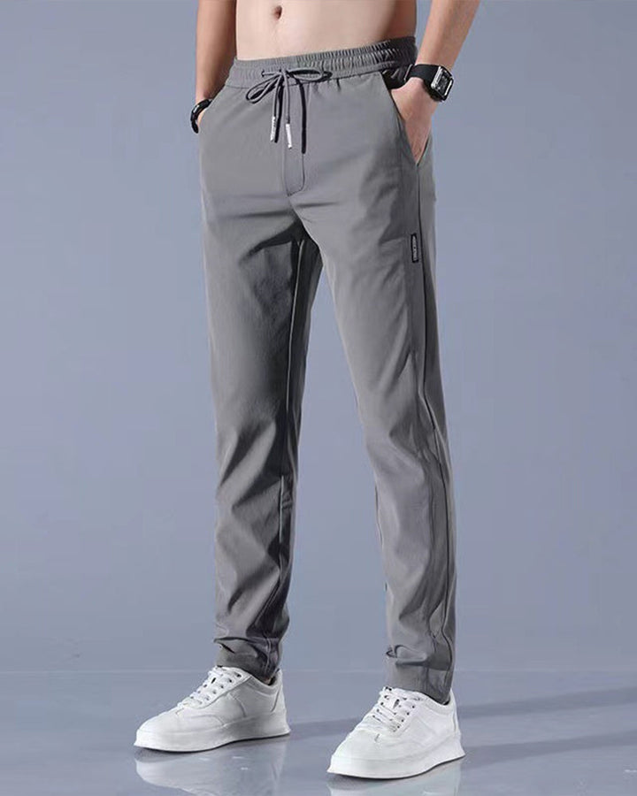 Graue Herren-Sporthose, elastisch, atmungsaktiv, mit Kordelzug, ideal für Fitness und Freizeit.