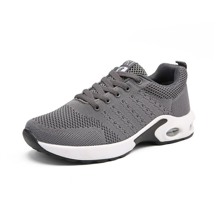 Grauer Sportschuh, atmungsaktives Mesh, rutschfeste Sohle, ideal für Laufen und Fitness.