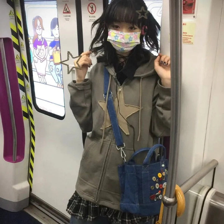 Mädchen in grauem Hoodie mit Sternen, bunter Maske, blauer Tasche in U-Bahn.