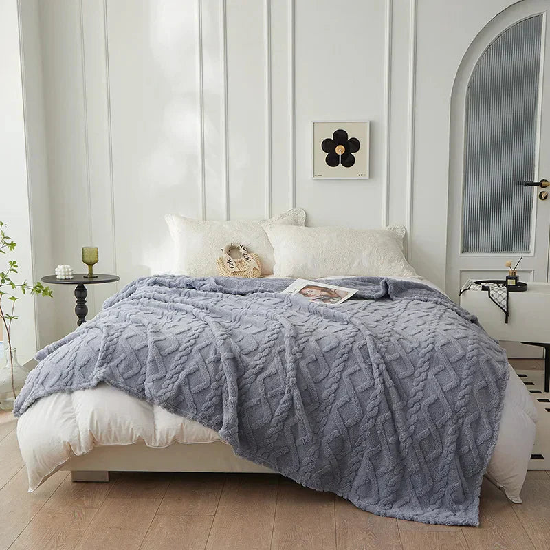 Graue Strickdecke auf weißem Bett in modernem Schlafzimmer, gemütliche Wohnkultur.