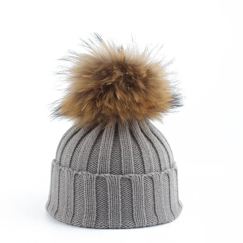 Graue Strickmütze mit braunem Kunstfellbommel, Wintermode, Unisex-Accessoire.