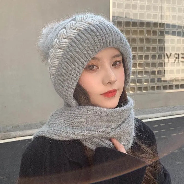Graue Strickmütze mit Zopfmuster und Bommel, Damenmode, Winteraccessoire, warm und stilvoll.