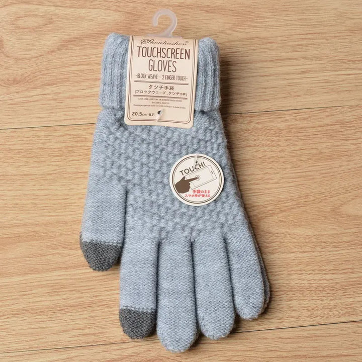 Graue Touchscreen-Handschuhe aus Wolle mit Etikett auf Holzboden.