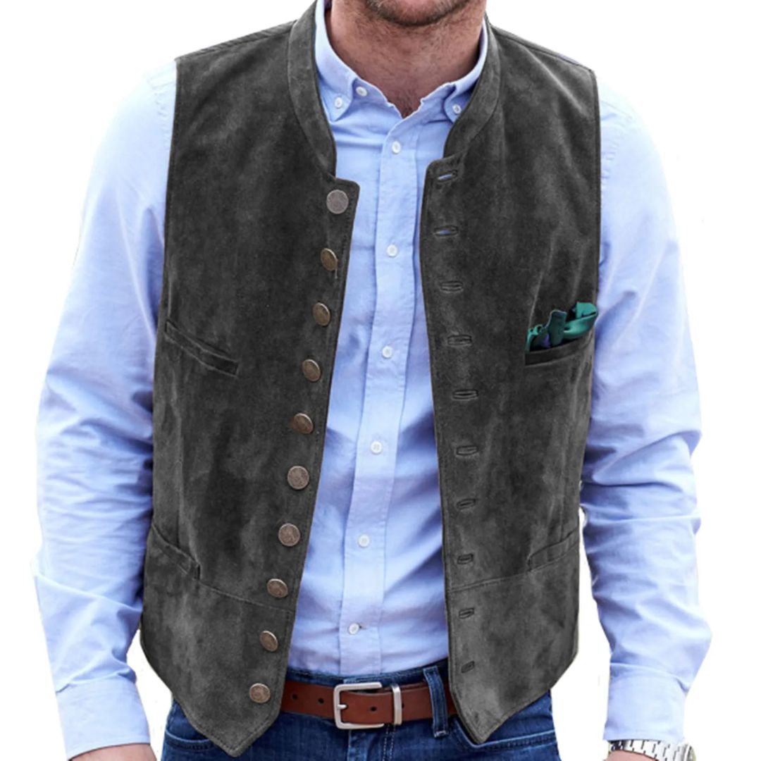 Graue Herrenweste aus Wildleder, traditionell, mit Knöpfen, über hellblauem Hemd getragen.