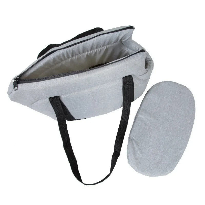 Graue Wickeltasche mit schwarzen Trägern und passender Wickelunterlage, ideal für unterwegs.