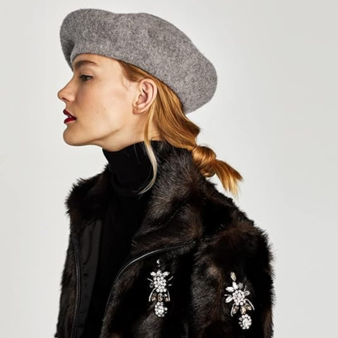 Frau mit grauem Woll-Baskenmütze, schwarzer Pelzjacke, Schmuckdetails, Mode, Herbst/Winter.