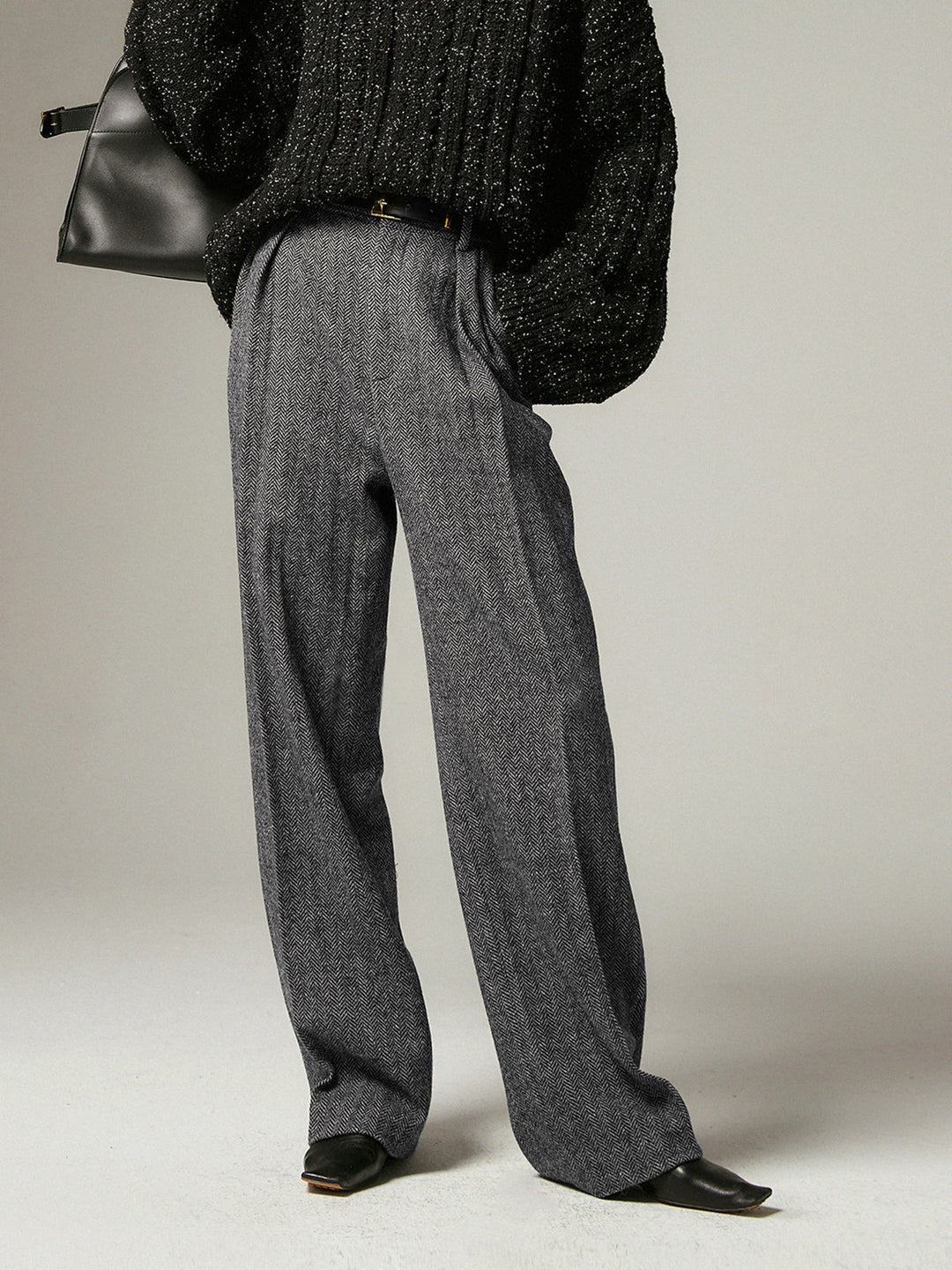Damenhose grau, weit geschnitten, eleganter Stil, aus Wolle, kombiniert mit schwarzem Pullover.