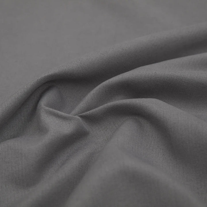 Grauer Baumwollstoff, weiche Textur, ideal für Bekleidung und Heimtextilien.