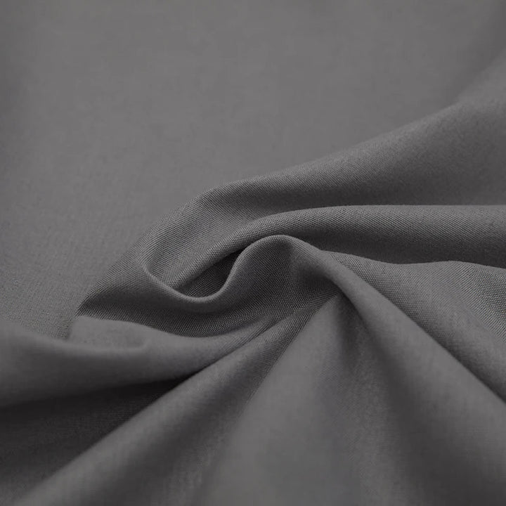 Grauer Baumwollstoff, weiche Textur, ideal für Bekleidung und Heimtextilien.