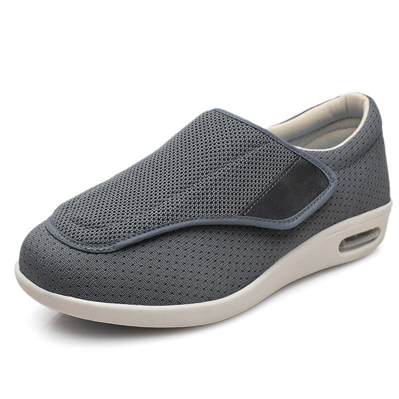 Grauer orthopädischer Schuh mit Klettverschluss, atmungsaktivem Mesh, bequeme Sohle.