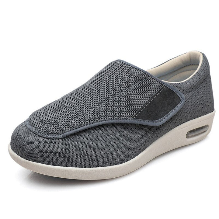Grauer orthopädischer Schuh mit Klettverschluss, atmungsaktivem Mesh, bequeme Sohle.