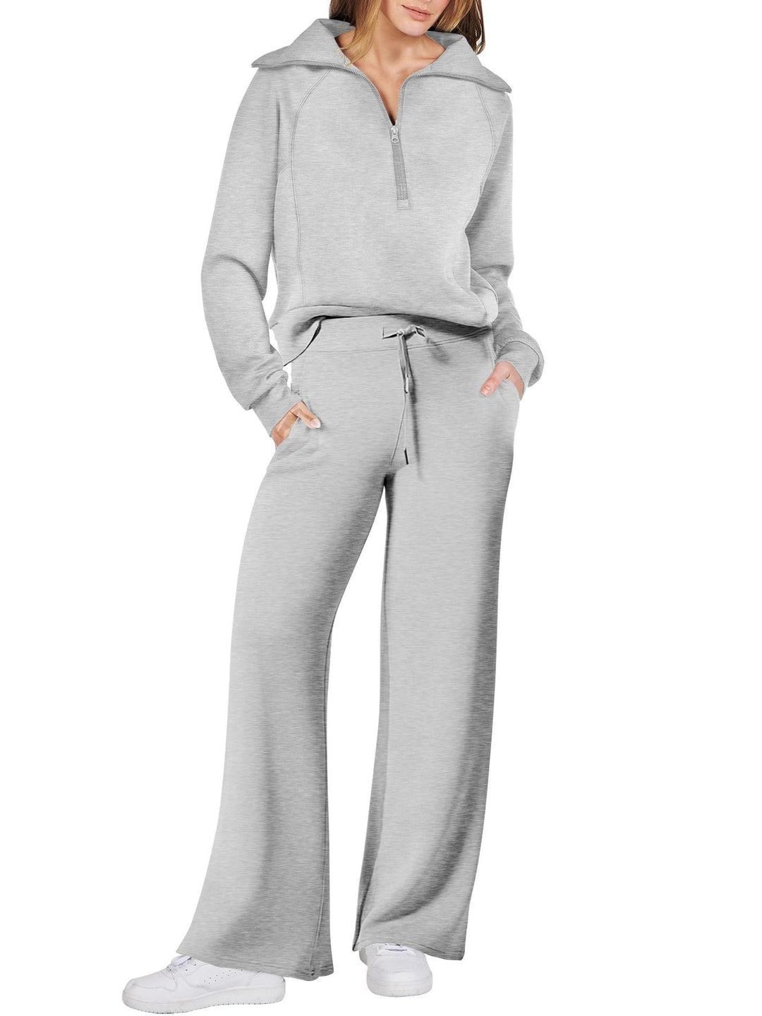 Frau in grauem Jogginganzug, Reißverschluss, weite Hose, Freizeitmode, bequeme Kleidung.