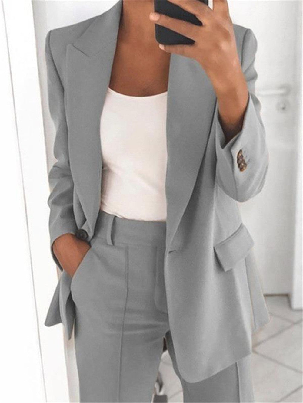 Grauer Damenanzug, Blazer und Hose, elegantes Business-Outfit, Büro-Mode, klassischer Stil.