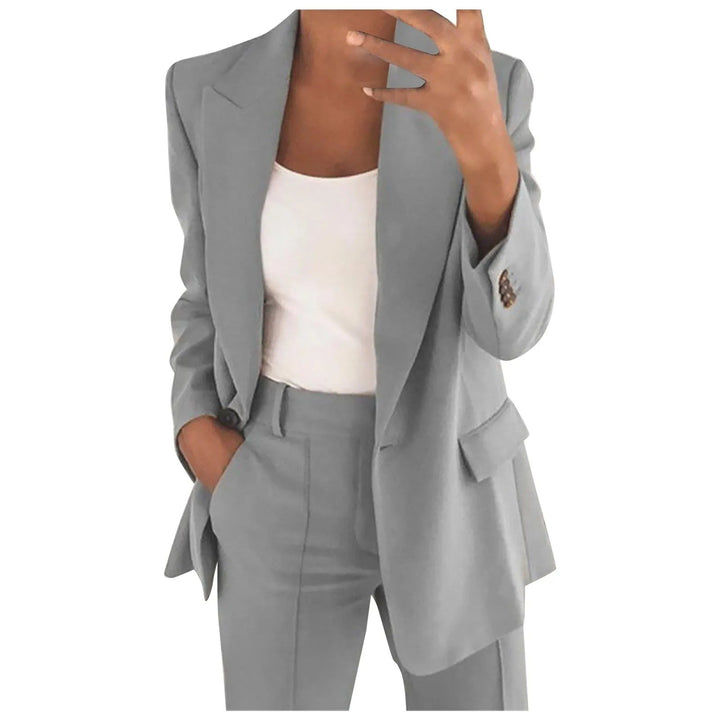 Frau im grauen Anzug mit weißem Top, Businessmode, eleganter Damenblazer, Bürooutfit.