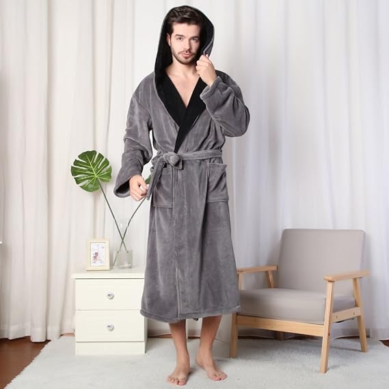 Mann im grauen Fleece-Bademantel mit Kapuze, stehend im Wohnzimmer, gemütliche Heimkleidung.