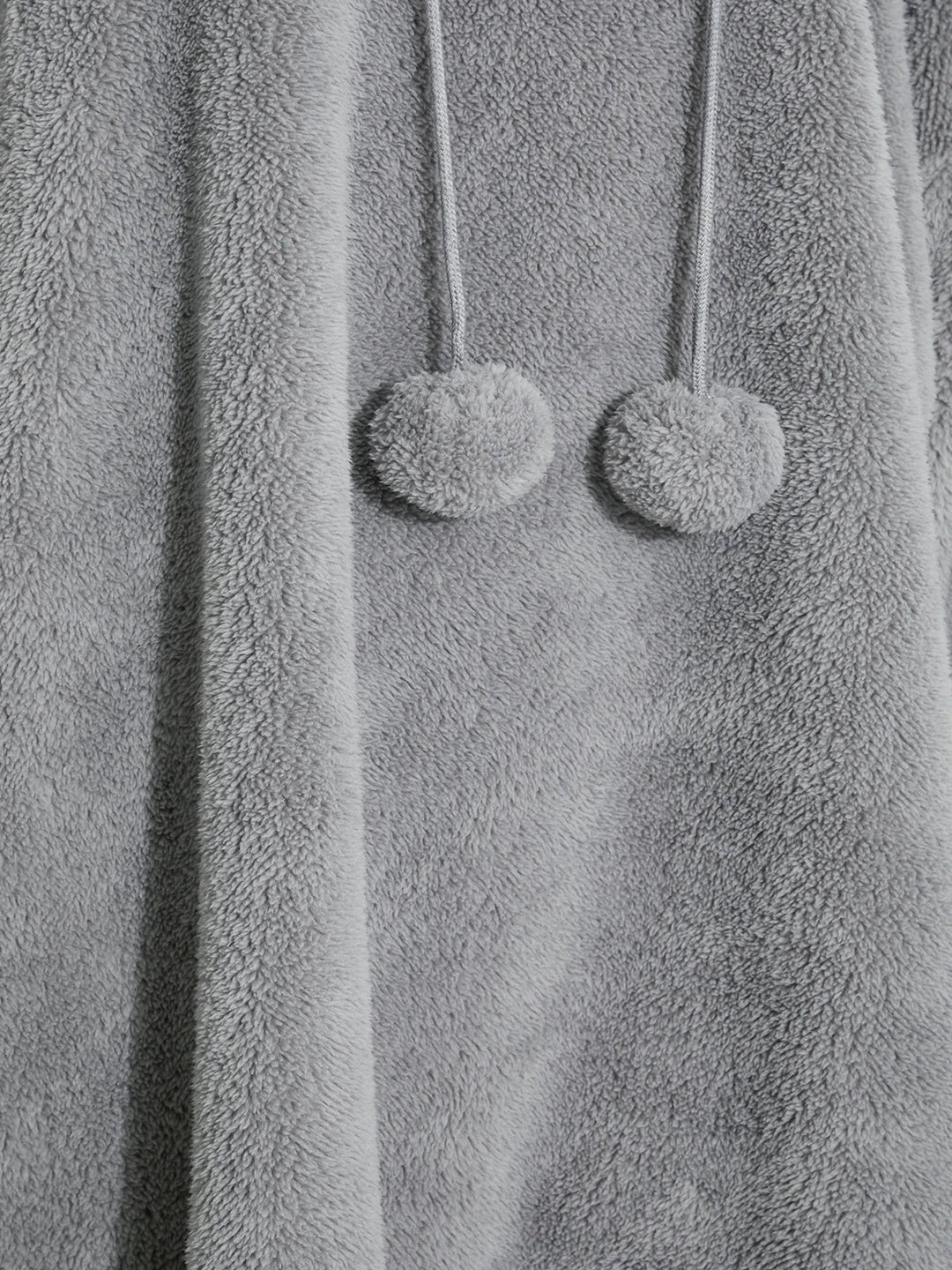Grauer Fleece-Bademantel mit Kapuze und Pompons, weiches Material, gemütliche Damenmode.