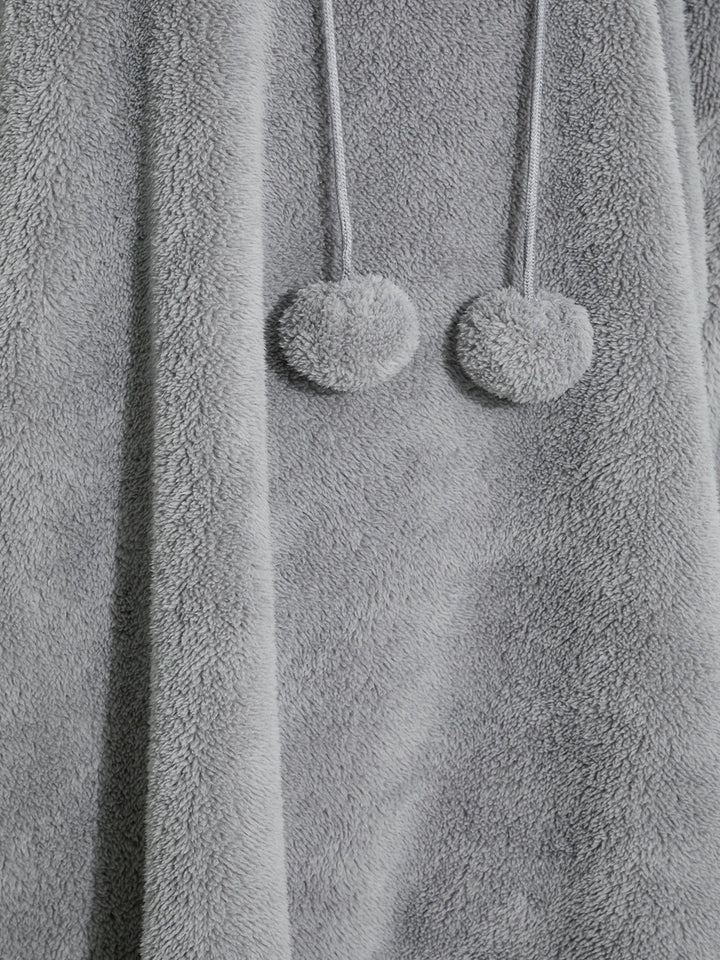 Grauer Fleece-Bademantel mit Kapuze und Pompons, weiches Material, gemütliche Damenmode.