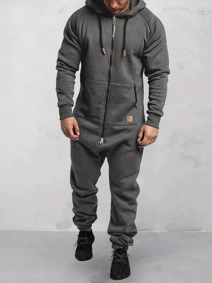Mann in grauem Einteiler-Jumpsuit mit Kapuze, Reißverschluss, Freizeitmode, bequem, modern.