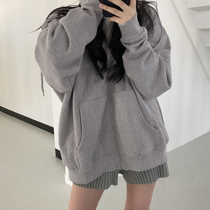 Frau in grauem Kapuzenpullover, lässiger Stil, modische Freizeitkleidung, Selfie.