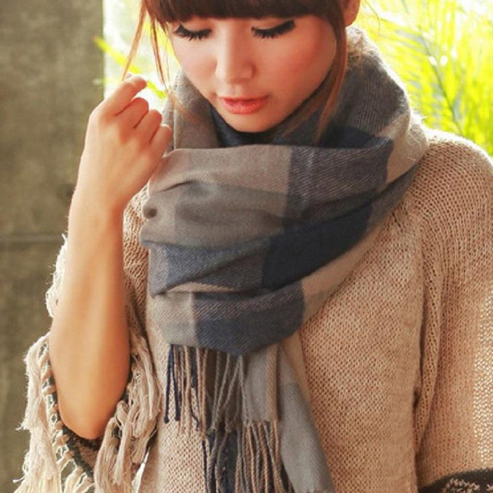Frau mit grauem kariertem Schal aus Wolle, modisches Accessoire, Herbst-Winter-Mode.