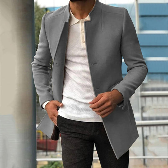 Grauer Herrenmantel, Stehkragen, elegantes Design, über weißem Hemd, moderne Herrenmode.
