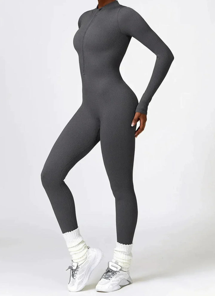 Damen grauer Jumpsuit, langärmelig, figurbetont, Reißverschluss, sportlich, modisch.
