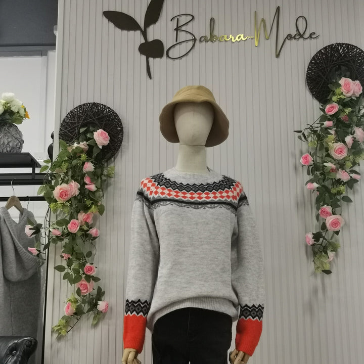 Grauer Pullover mit rotem Muster auf Schaufensterpuppe, umgeben von Rosen, Babura Mode.
