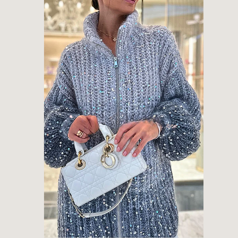 Frau in glitzerndem Strickpullover mit weißer Designer-Handtasche, elegant, modisch.