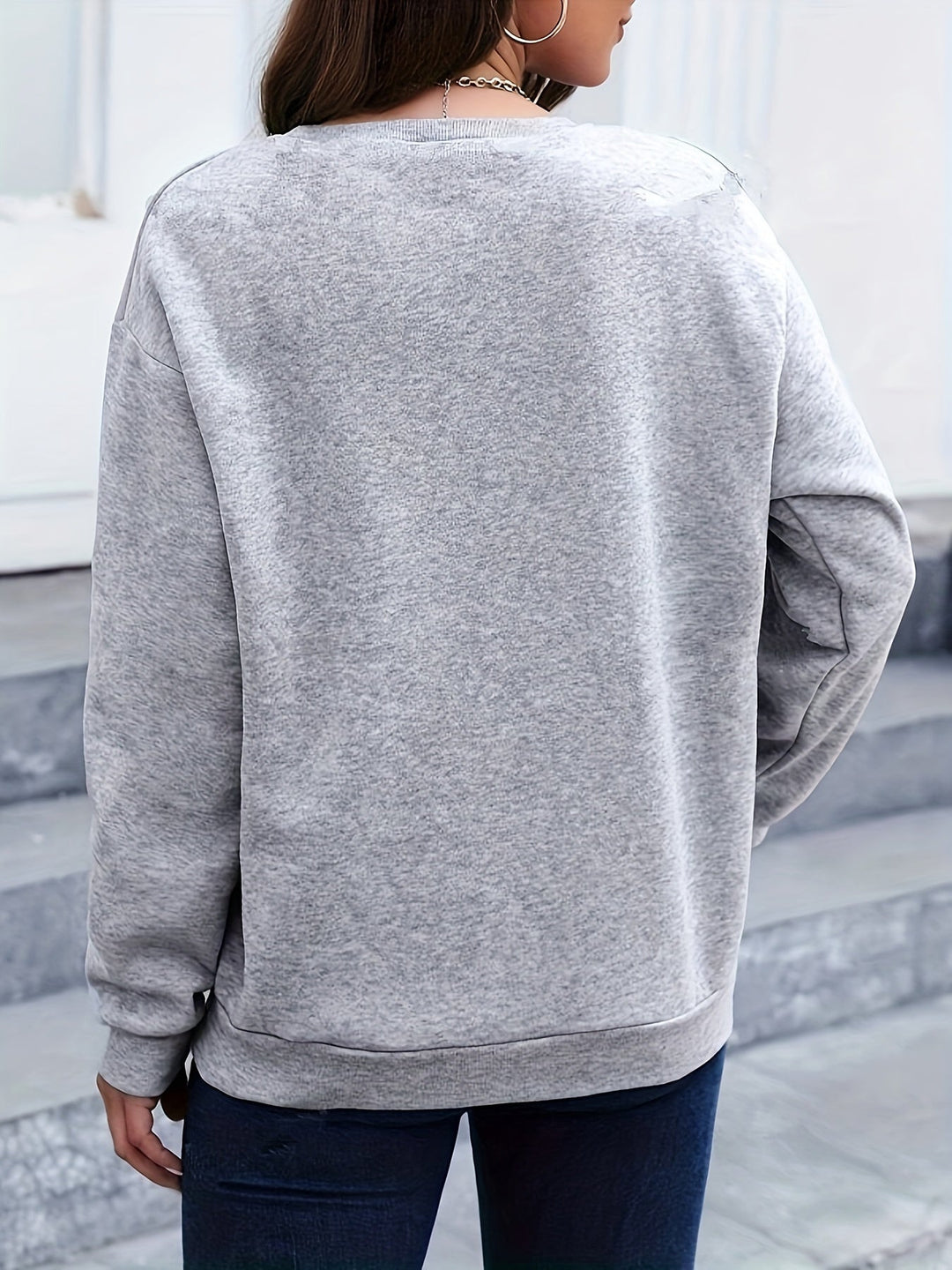 Frau in grauem Sweatshirt, Rückansicht, lässige Mode, Herbstkleidung, urbaner Stil.