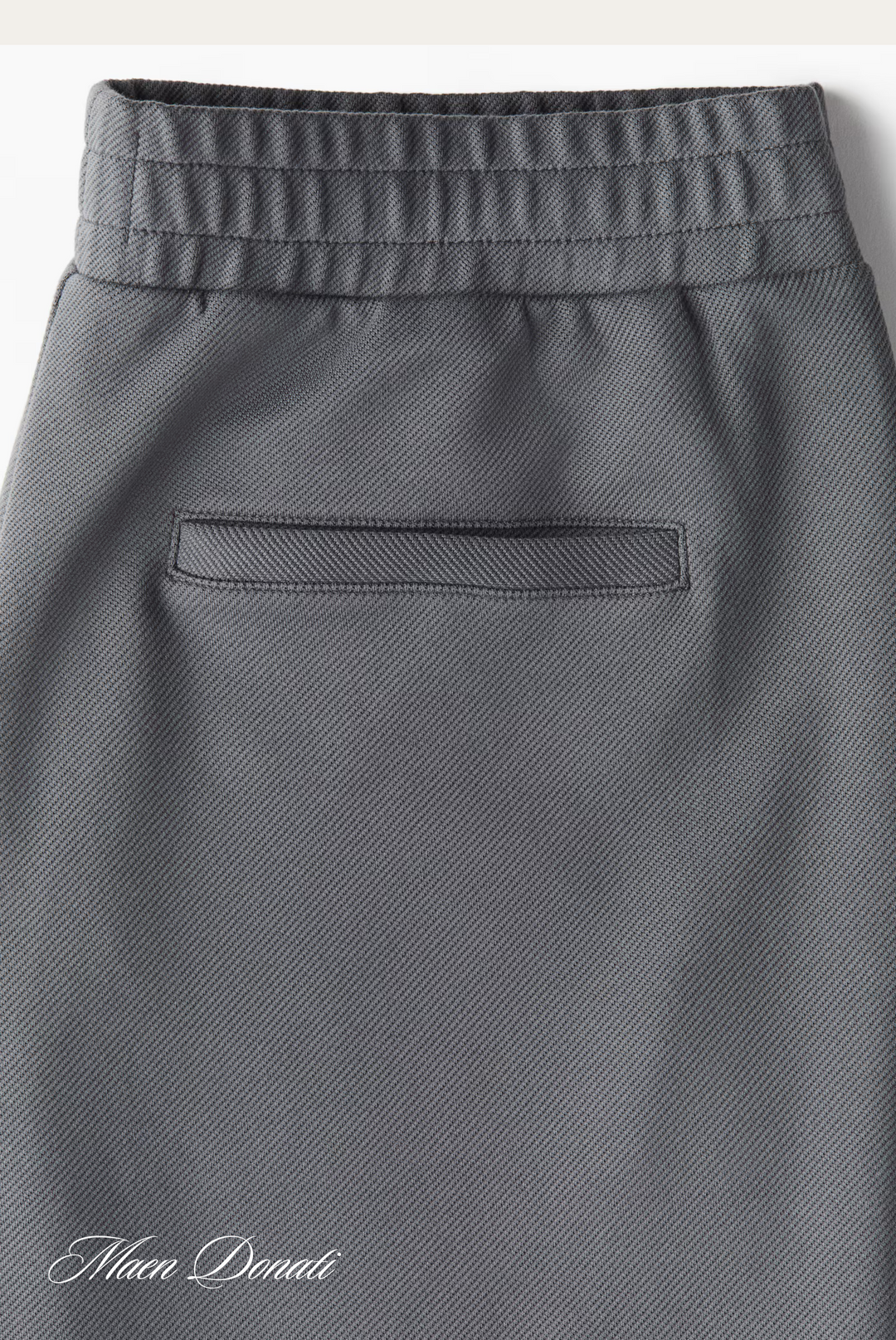 Graue Herrenhose mit elastischem Bund und Gesäßtasche, elegante Businessmode.