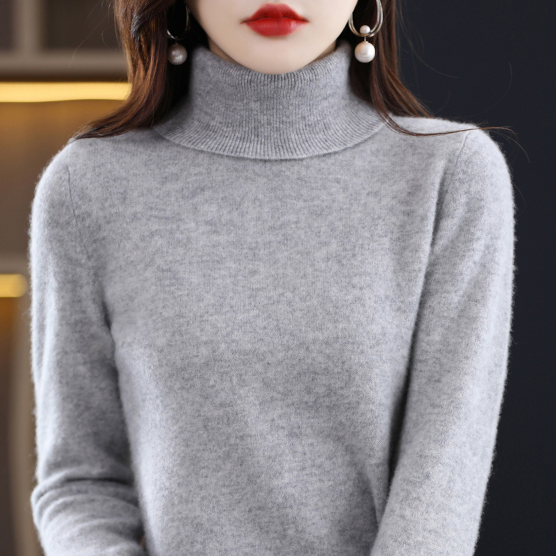 Frau in grauem Rollkragenpullover aus Kaschmir, elegante Ohrringe, Mode, Herbst-Winter-Look.