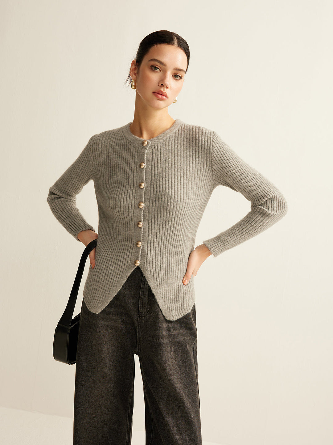 Frau in grauem Strickpullover mit Knöpfen, schwarze Jeans, modisch, elegant, Herbstmode.