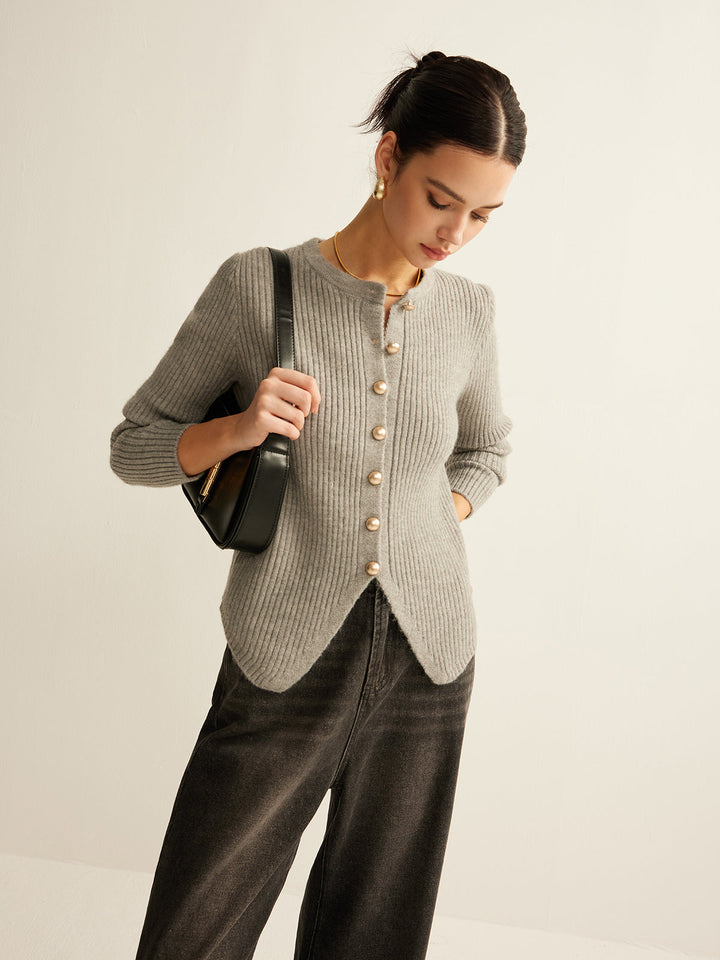 Frau trägt grauen Strickcardigan mit Perlenknöpfen, schwarze Tasche, modisch, elegant.