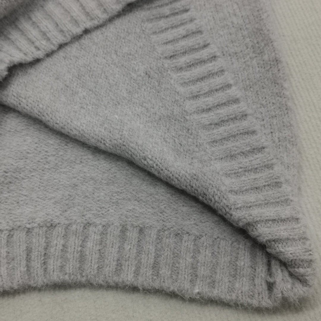 Grauer Kaschmirpullover, weiches Material, Nahaufnahme, Strickmode, luxuriös, warm, elegant.